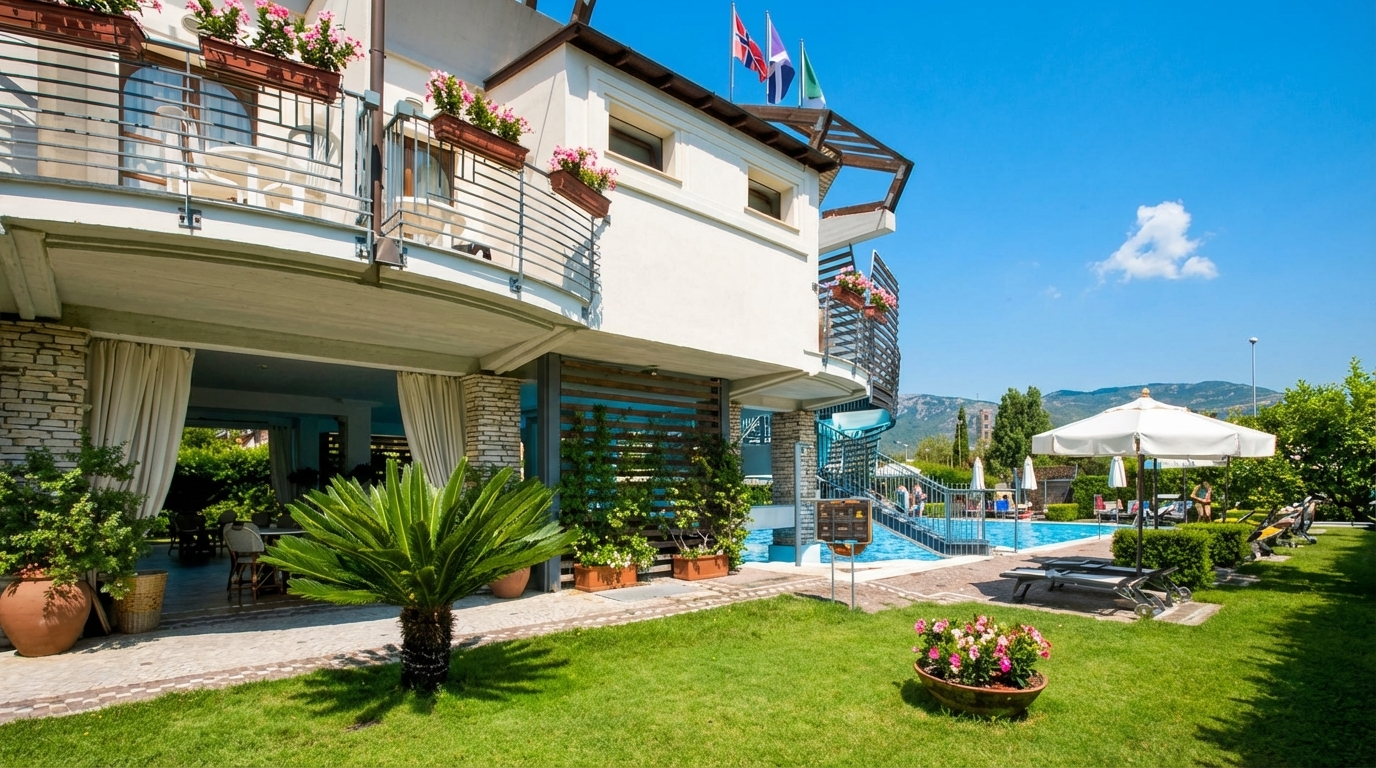 Lush green garden and patio area leading to the Hotel Poseidon pool.